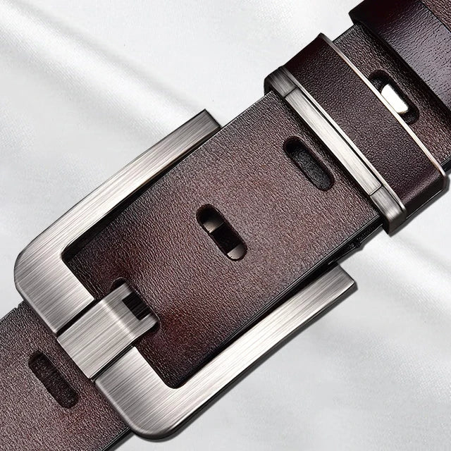 Brown leather belt with silver buckle on a light gray background